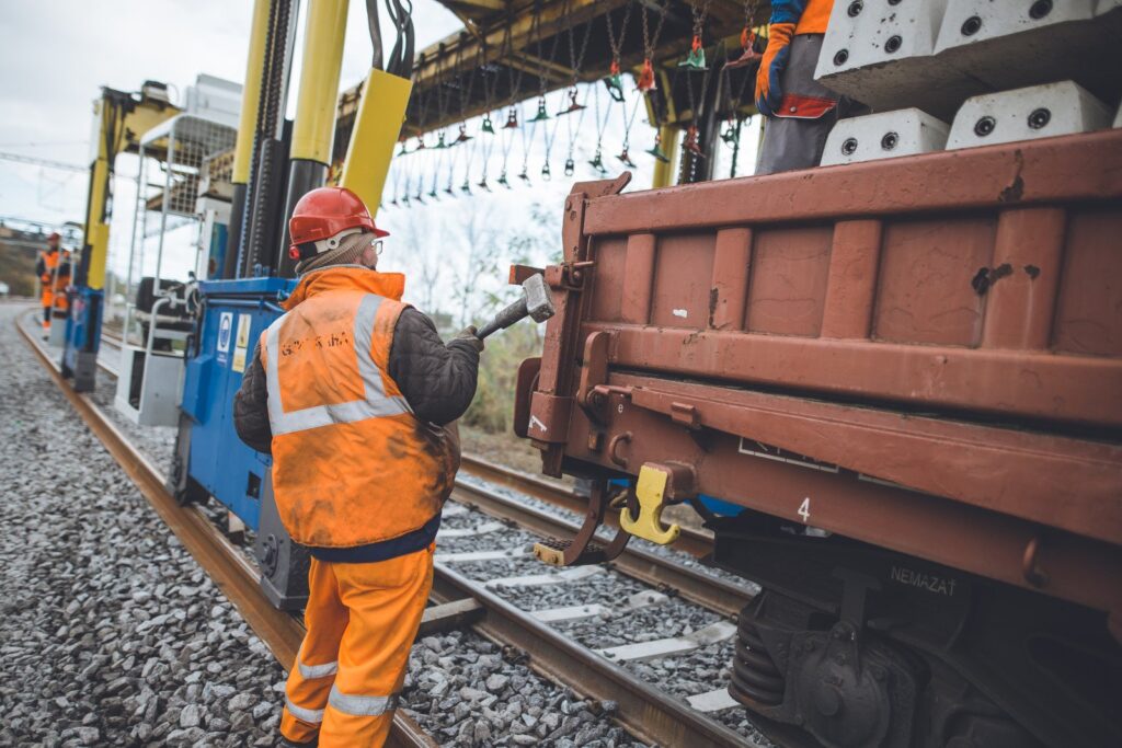 homme casqué chargé de l'entretien des grues ferroviaires