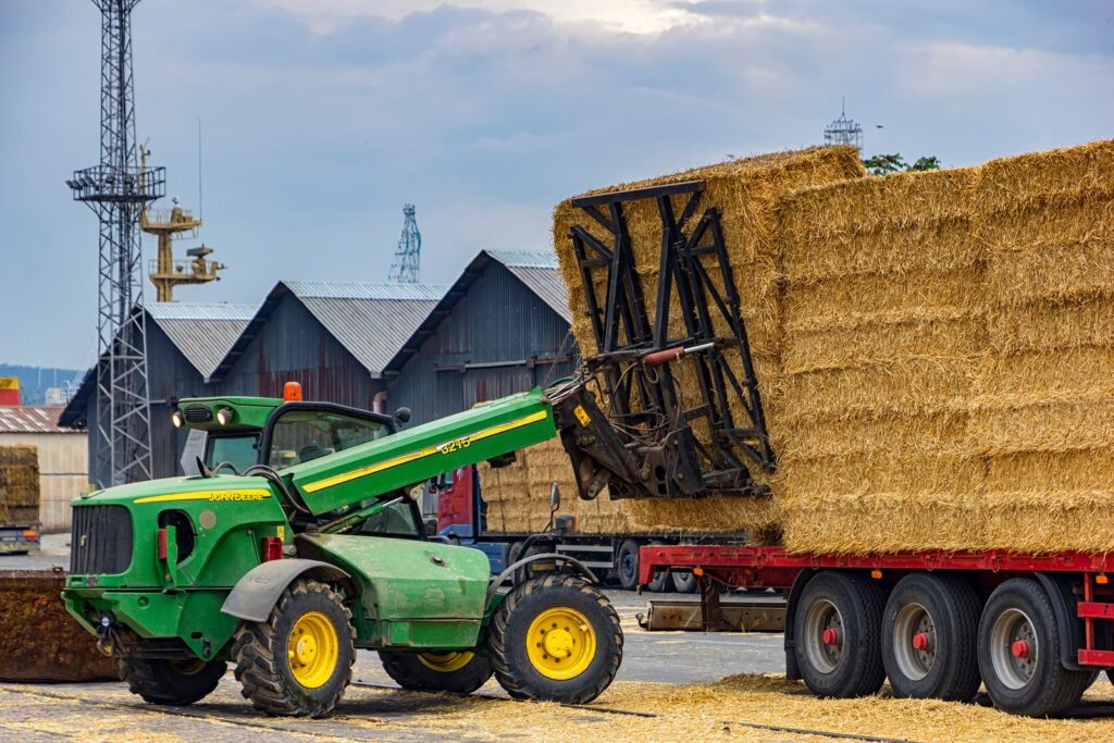 Teleskoplader transportiert Heuballen