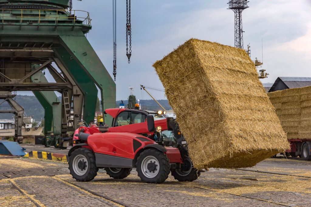 telescopic loader transporting bales of hay
